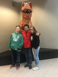 Students in front of a T-Rex statue